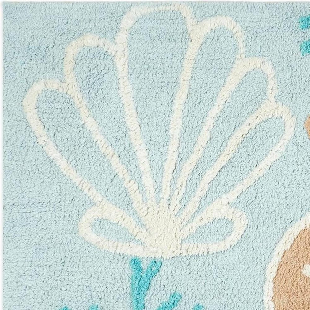 32" Blue Tan And White Cotton Seashells And Coral Bath Rug. Bath rug isolated on a plain white background, showing a white cotton surface.