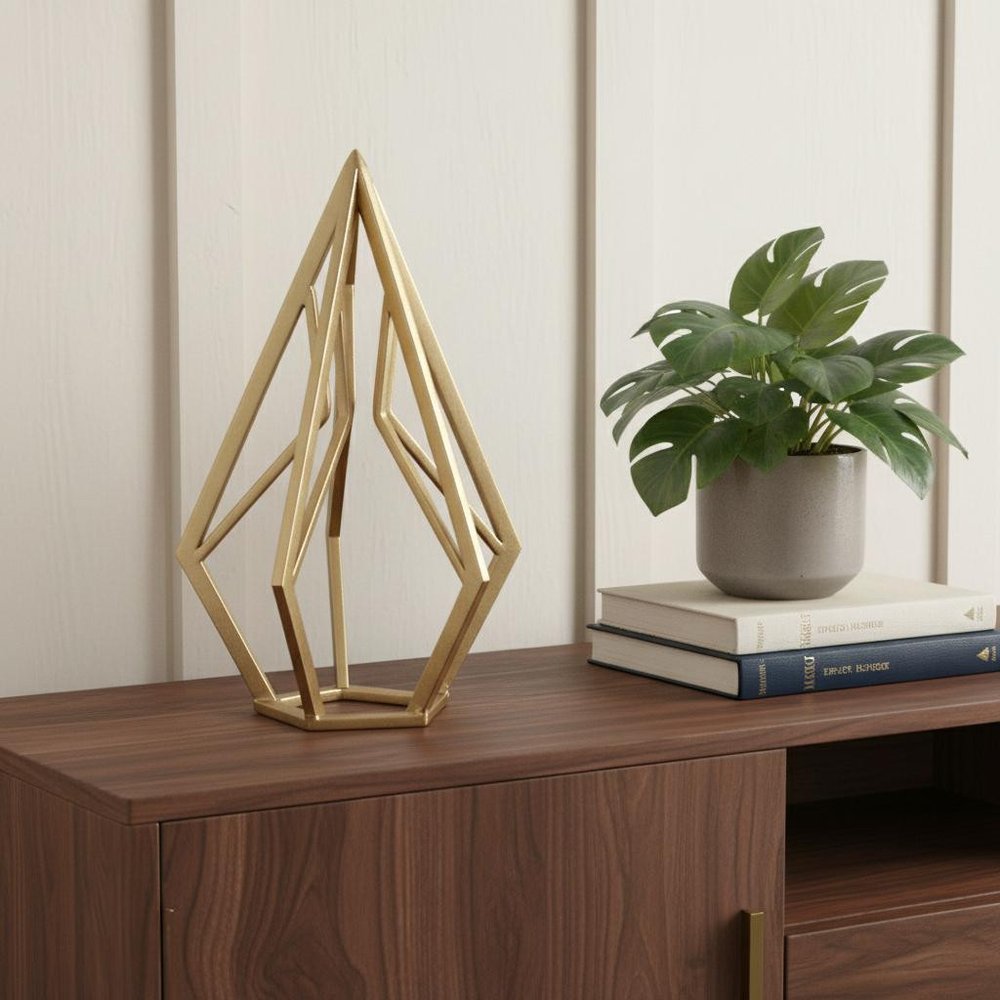 10" Gold Metal Open Geometric Tabletop Sculpture styled in a furnished interior with an off-white wall on a dark wood floor.