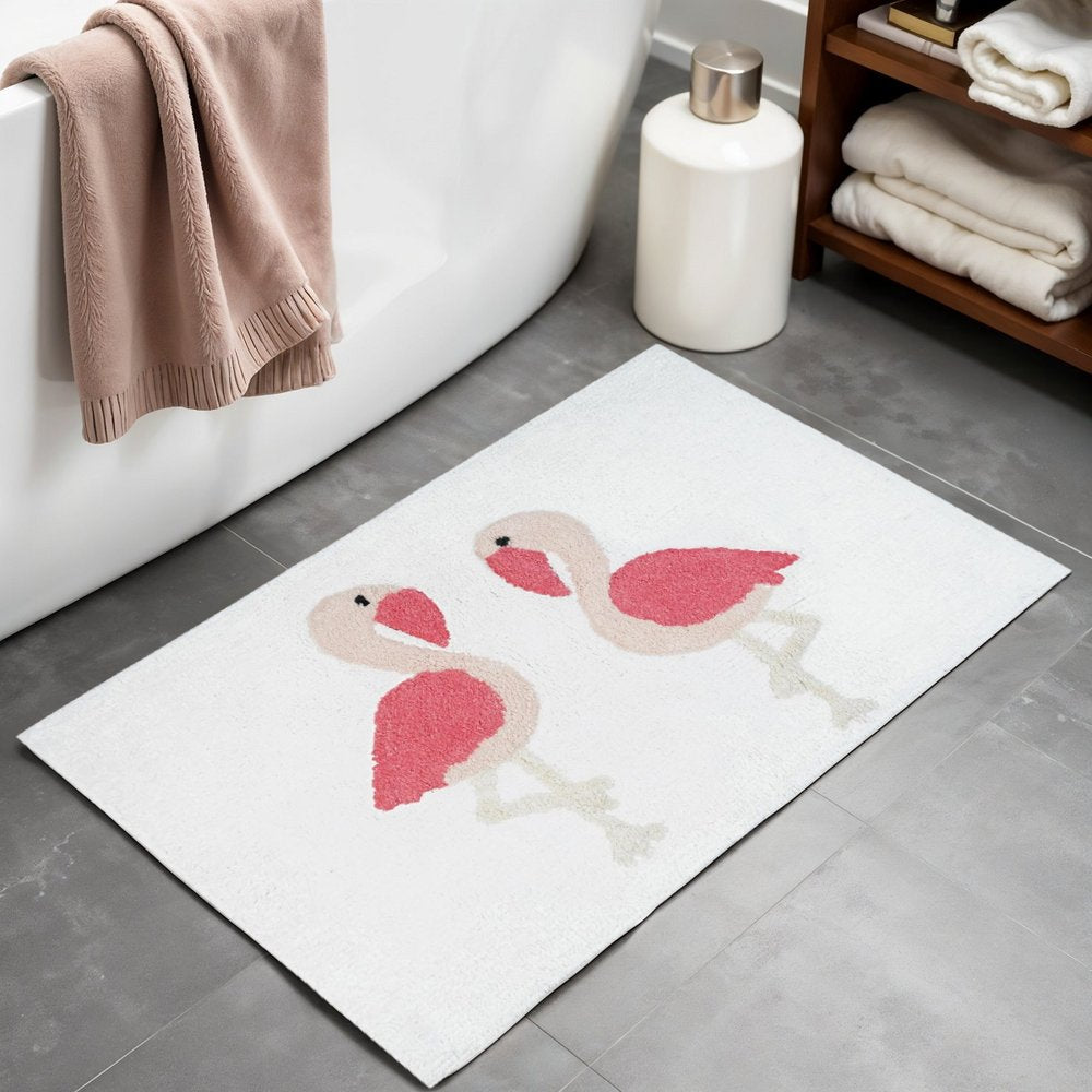 32" Pink And White Cotton Flamingo Bath Rug laid on a tiled floor in a furnished interior.