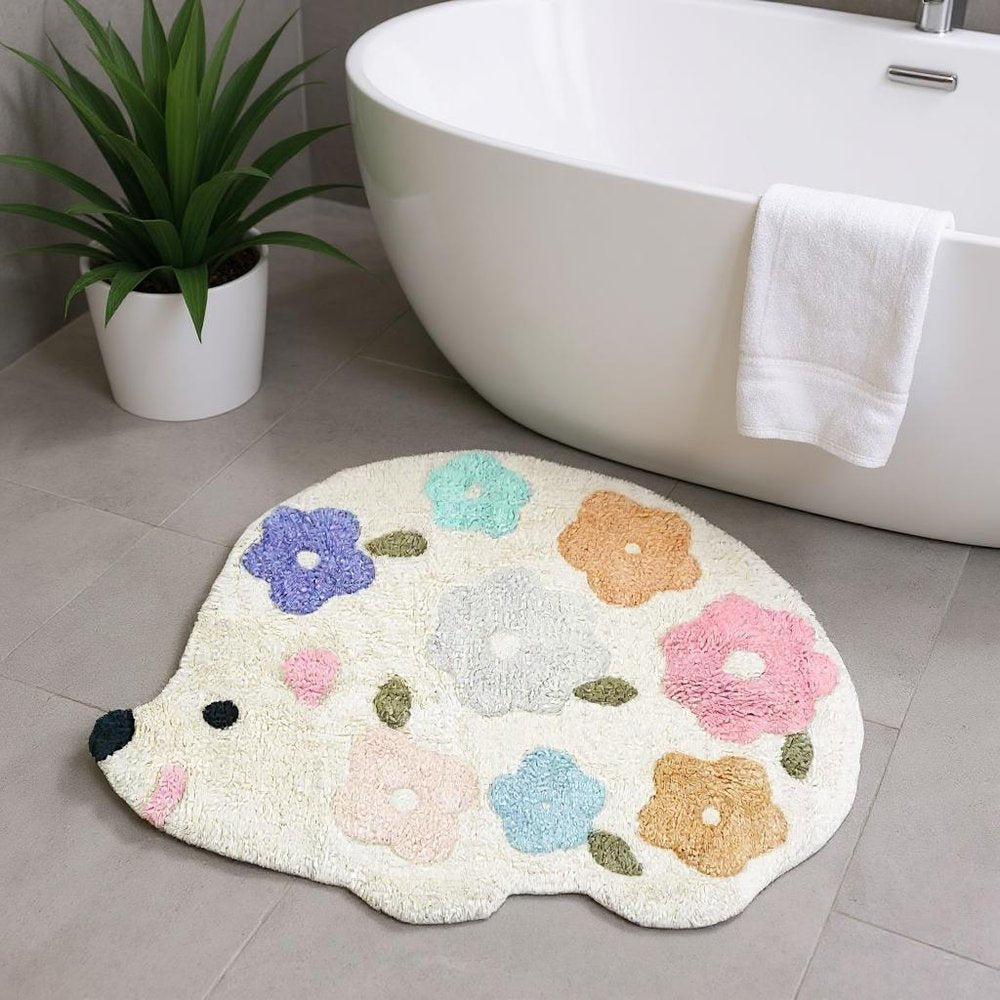 32" White Blue And Pink Cotton Hedgehog Floral Print Bath Rug laid on a tiled floor in a furnished interior.