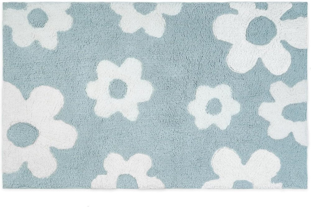 A blue cotton bath rug with a white floral pattern.