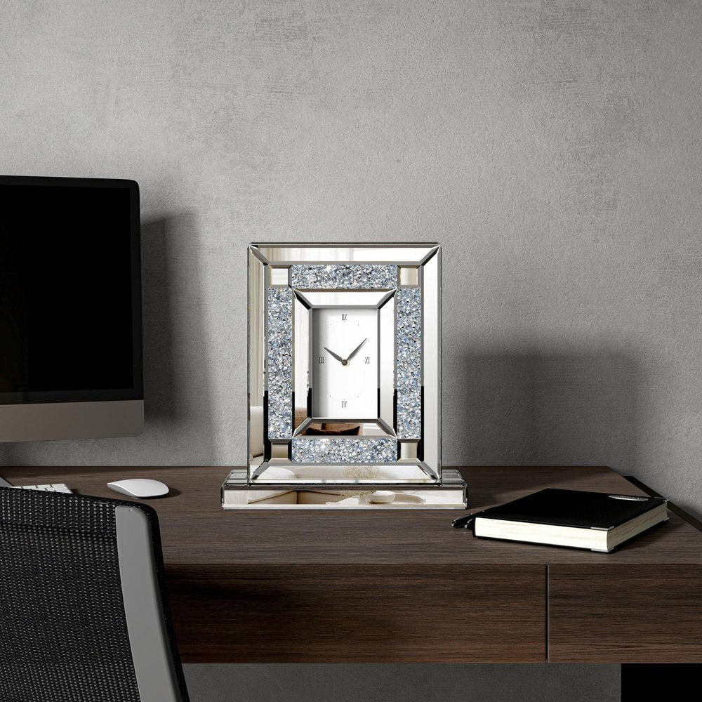 16" Silver And White Faux Crystal And Mirrored Glass Table Clock styled in a furnished interior with a light gray wall on a black floor.