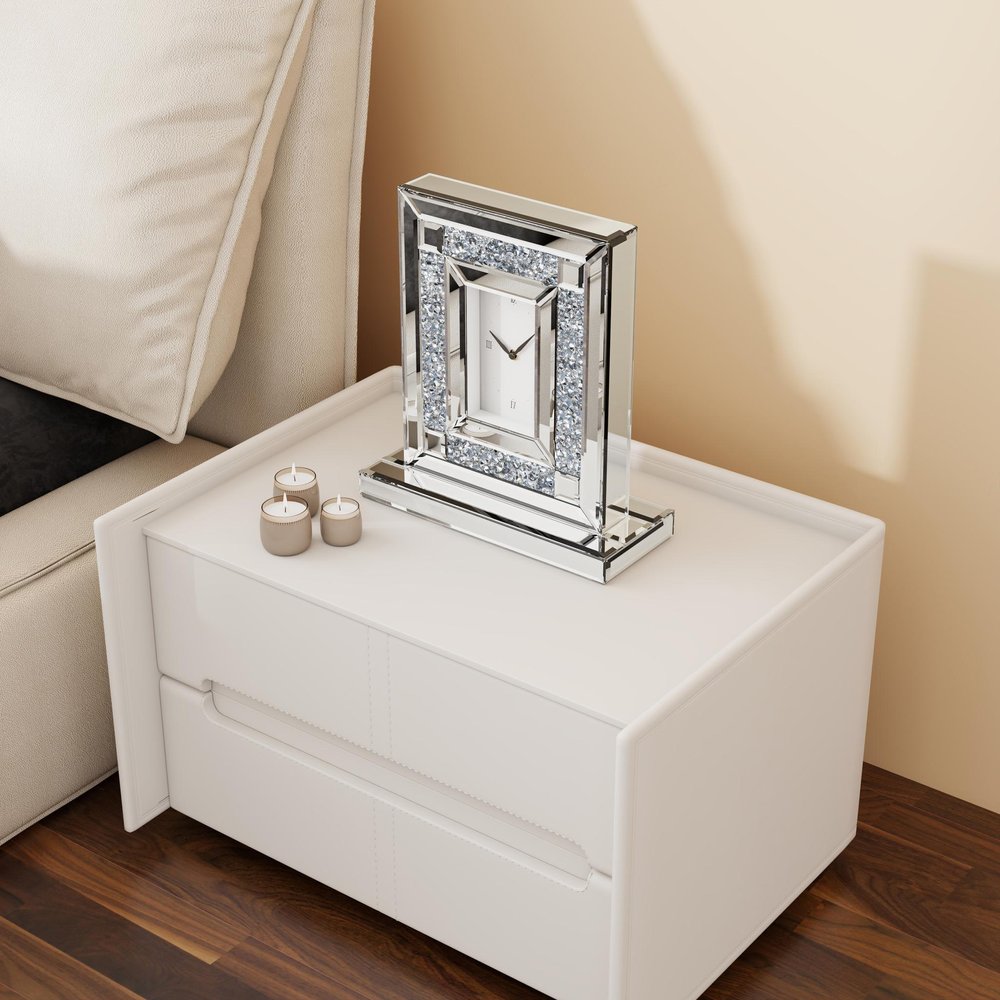 16" Silver And White Faux Crystal And Mirrored Glass Table Clock styled in a furnished interior with a cream wall on a dark wood floor.