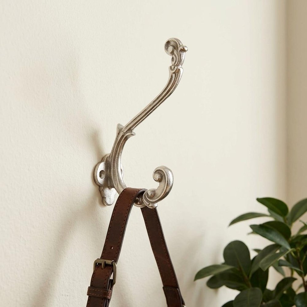 Set of Six Silver Cast Iron Baroque Scroll Wall Hooks in a home interior