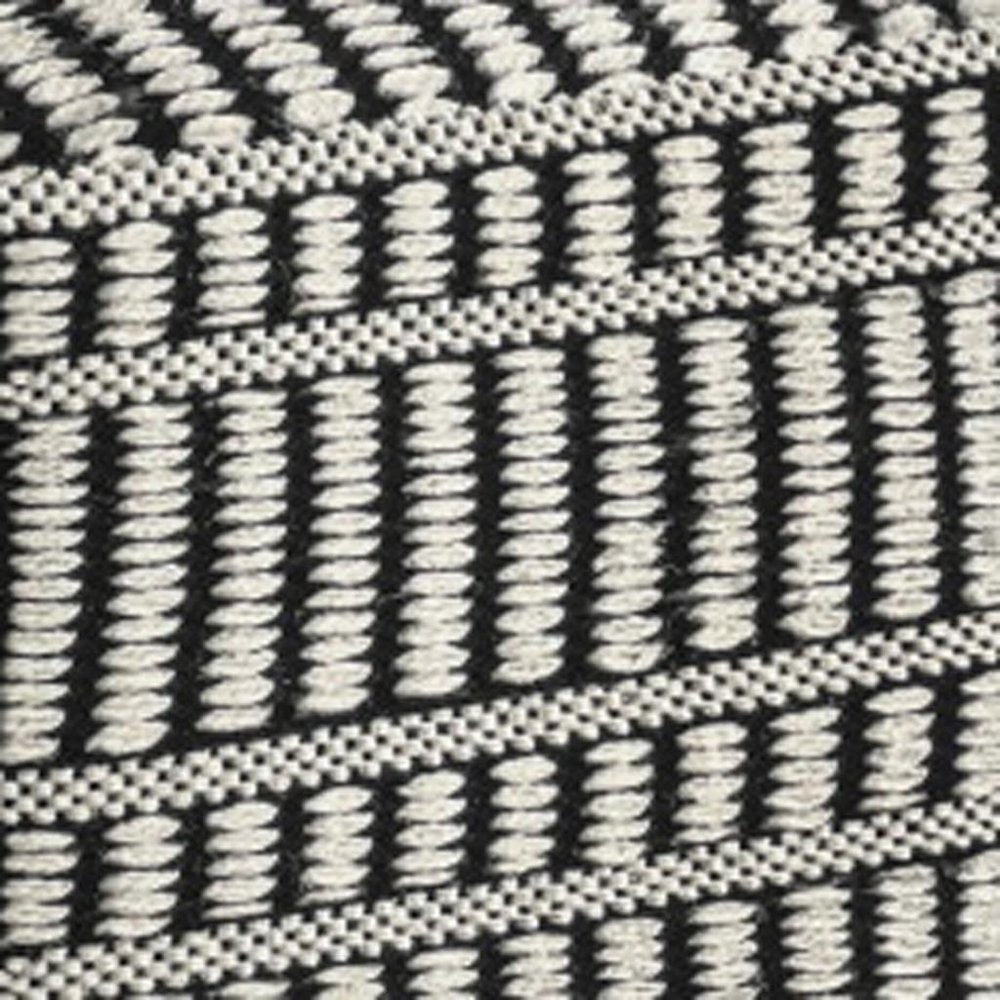 Close-up of 20" Black And White Polyester Geometric Outdoor Pouf Ottoman showing the white fabric texture.