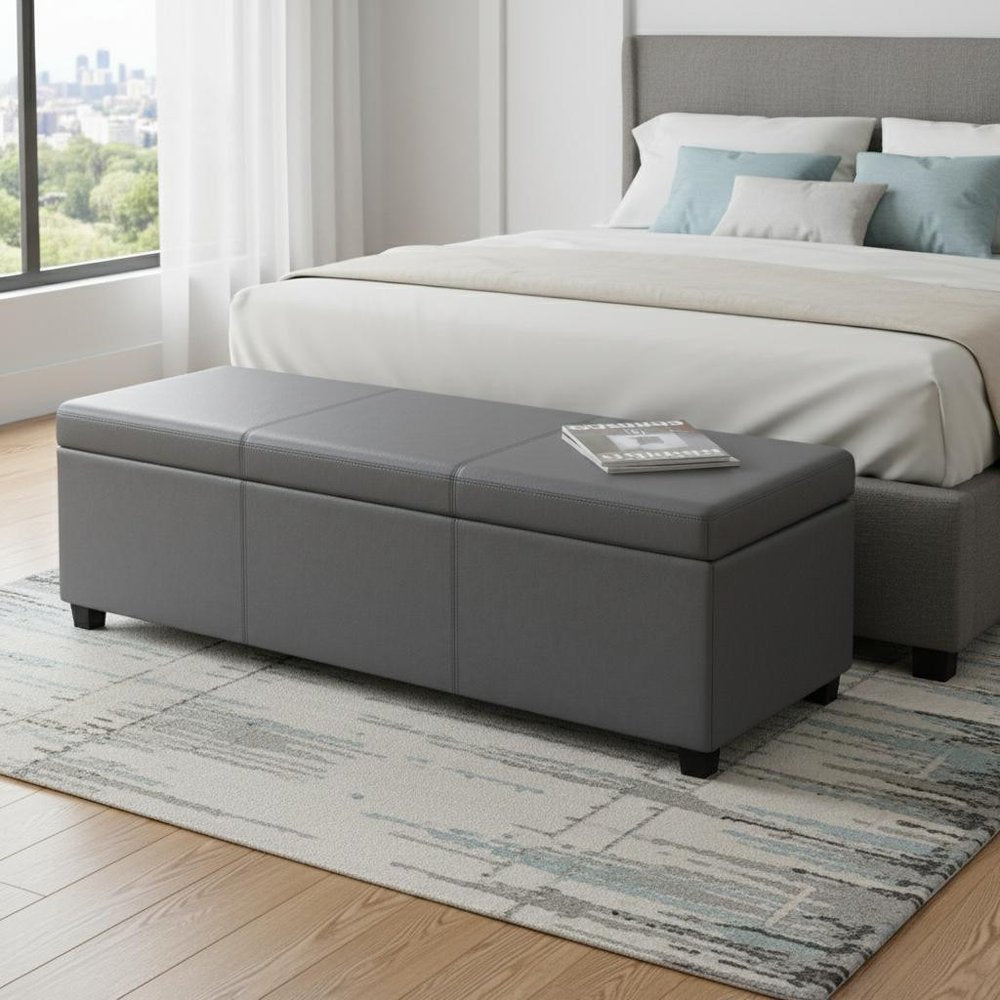 54" Slate Gray and Dark Brown Linen Blend and Solid Wood Upholstered Storage Bench With Flip Top styled in a furnished interior with a gray wall on a wood floor.
