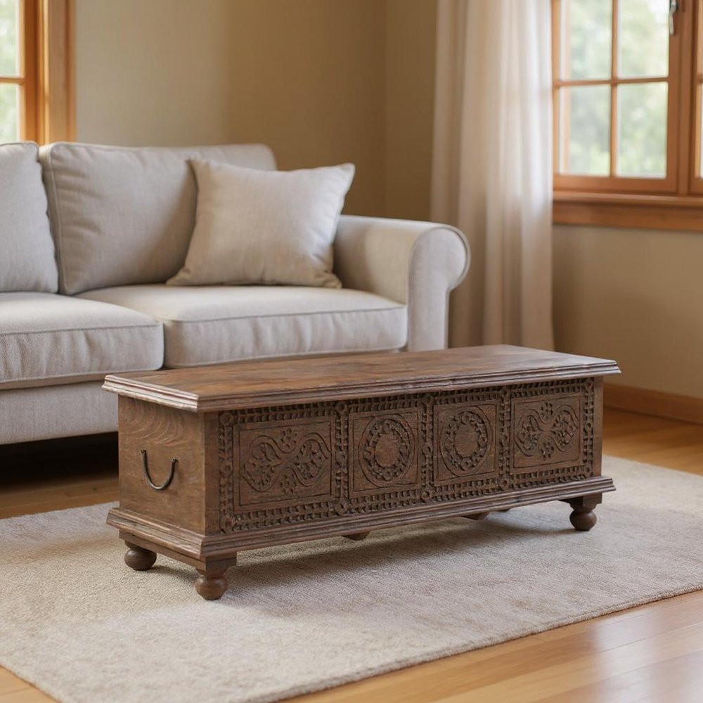 54" Brown Solid Wood Medallion Ottoman With Storage styled in a furnished interior with a tan wall on a wood floor.