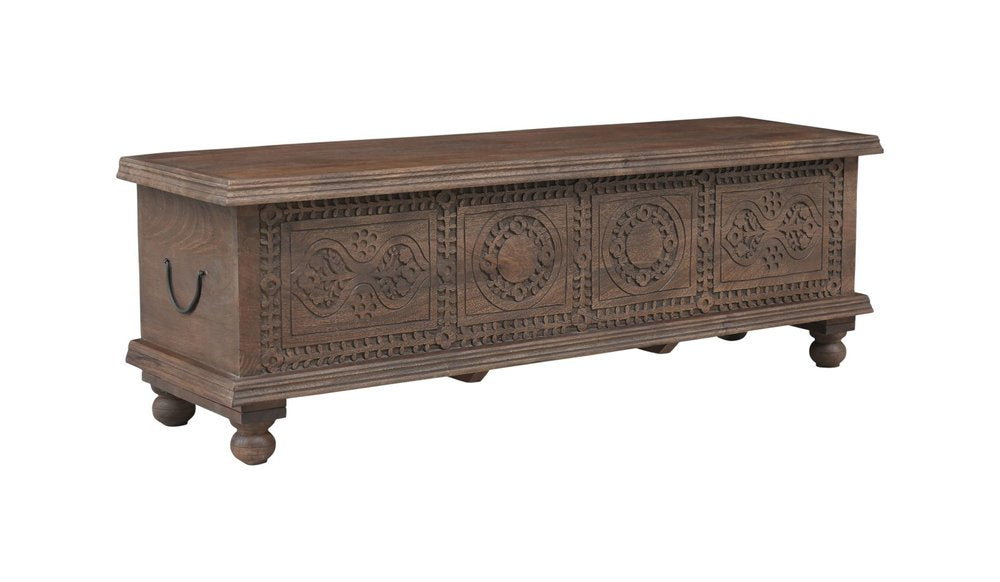 Brown solid wood storage ottoman with carved medallion details and black metal handles on a white background.
