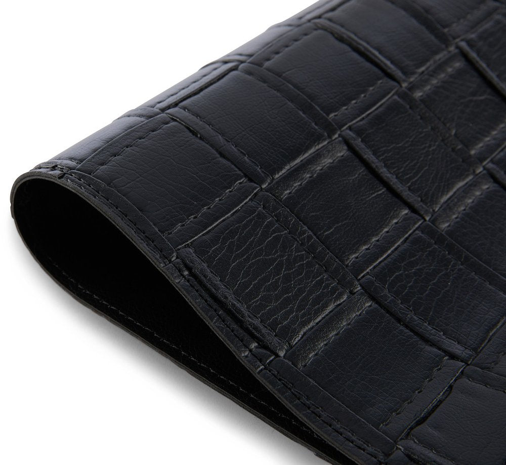 18" Set of Four Black Basketweave Faux Leather Placemats photographed against a dark studio background in black.