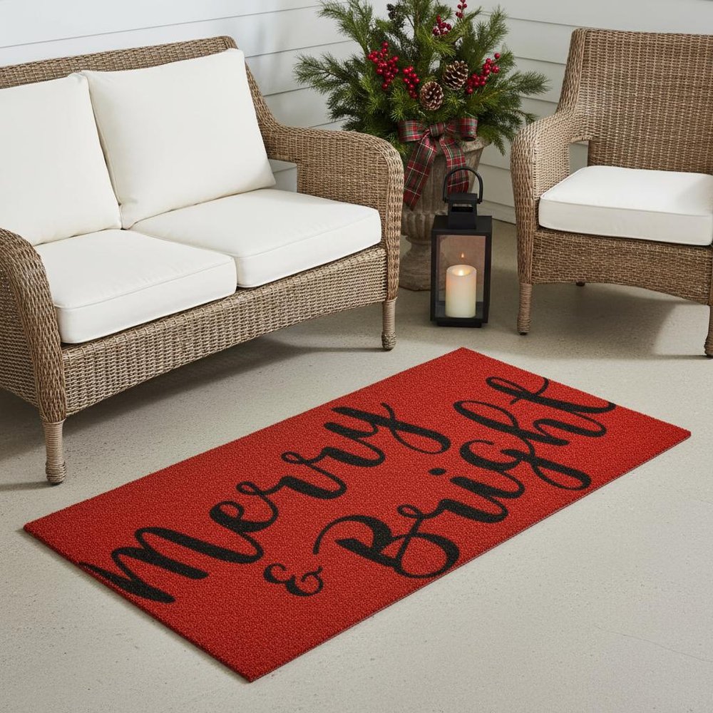 30" X 48" Red And Black Christmas Merry and Bright Outdoor Coir Door Mat styled in a furnished interior with an off-white wall on a tiled floor.