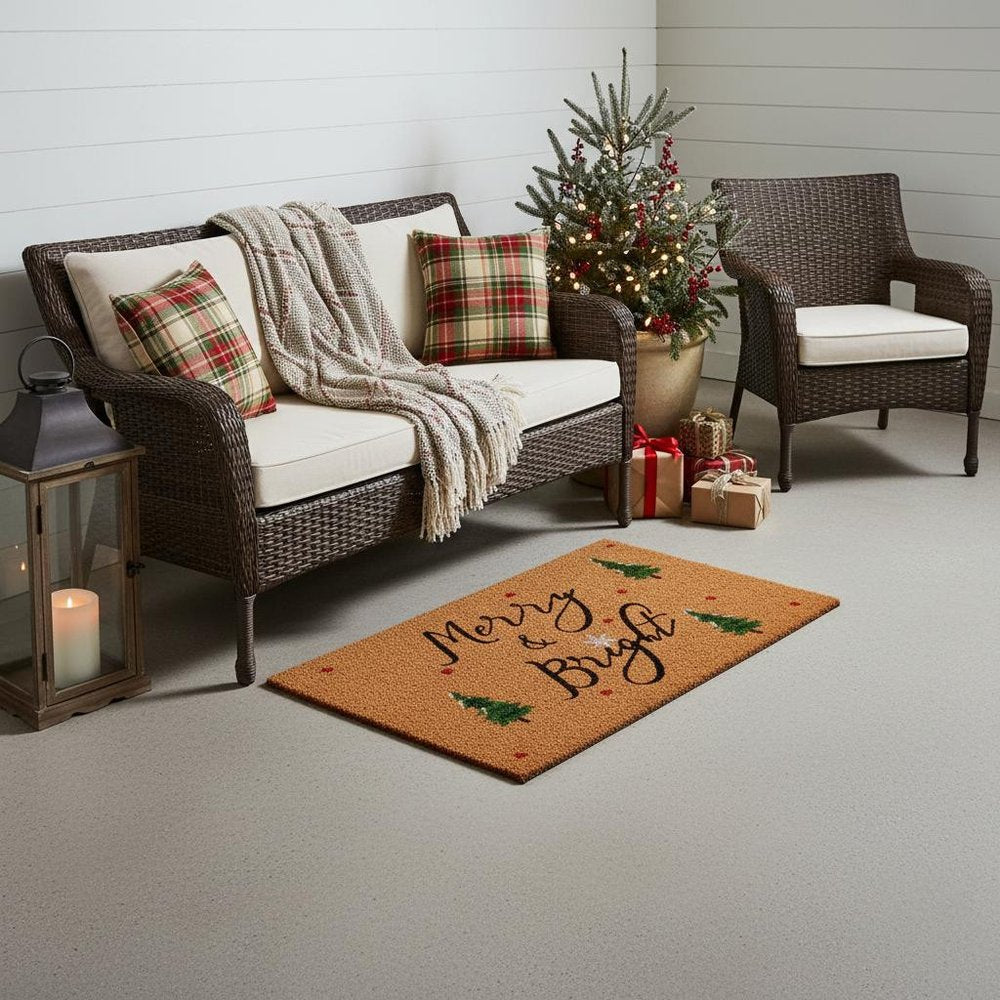 36" X 72" Brown Black And Green Christmas Merry and Bright Outdoor Coir Door Mat styled in a furnished interior with an off-white wall on a tiled floor.