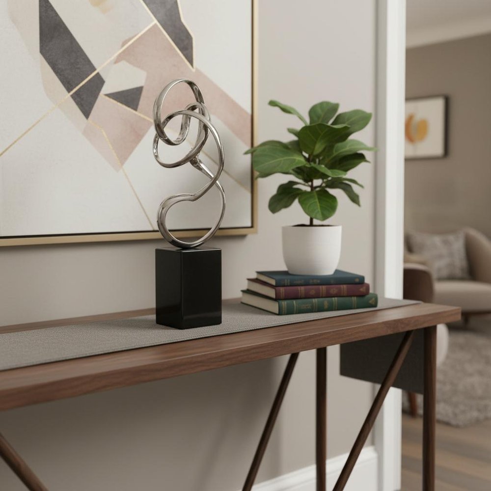 20" Silver And Black Aluminum And Marble Modern Abstract Tabletop Sculpture styled in a furnished interior with a light gray wall on a wood floor.