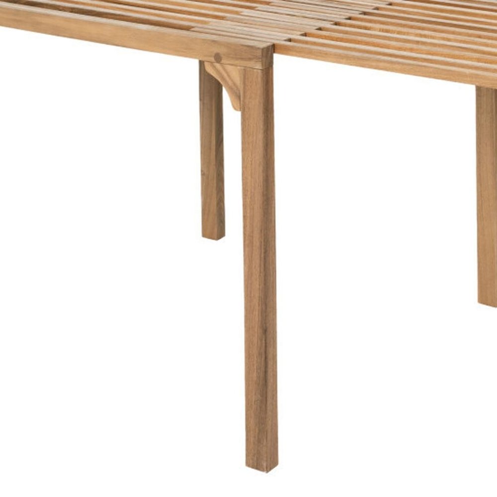 Close-up of a natural solid wood extendable outdoor dining table with slatted top and visible legs against a white background.