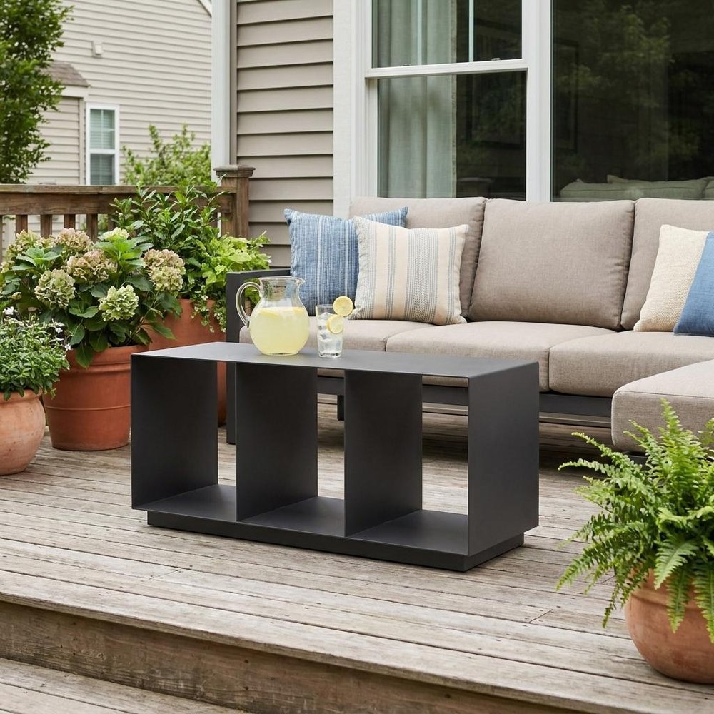 36" Charcoal Aluminum Outdoor Coffee Table shown outdoors on a patio with greenery.