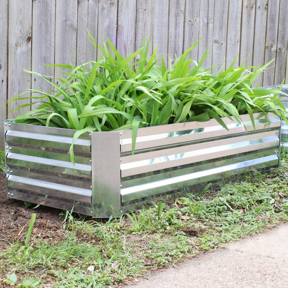 12" X 48" Silver Metal Rectangular Raised Garden Bed shown outdoors on a patio with greenery.