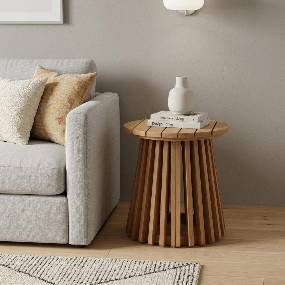 16" Natural Solid Wood Round Outdoor Side Table styled in a furnished interior with a tan wall on a wood floor in tan wood.