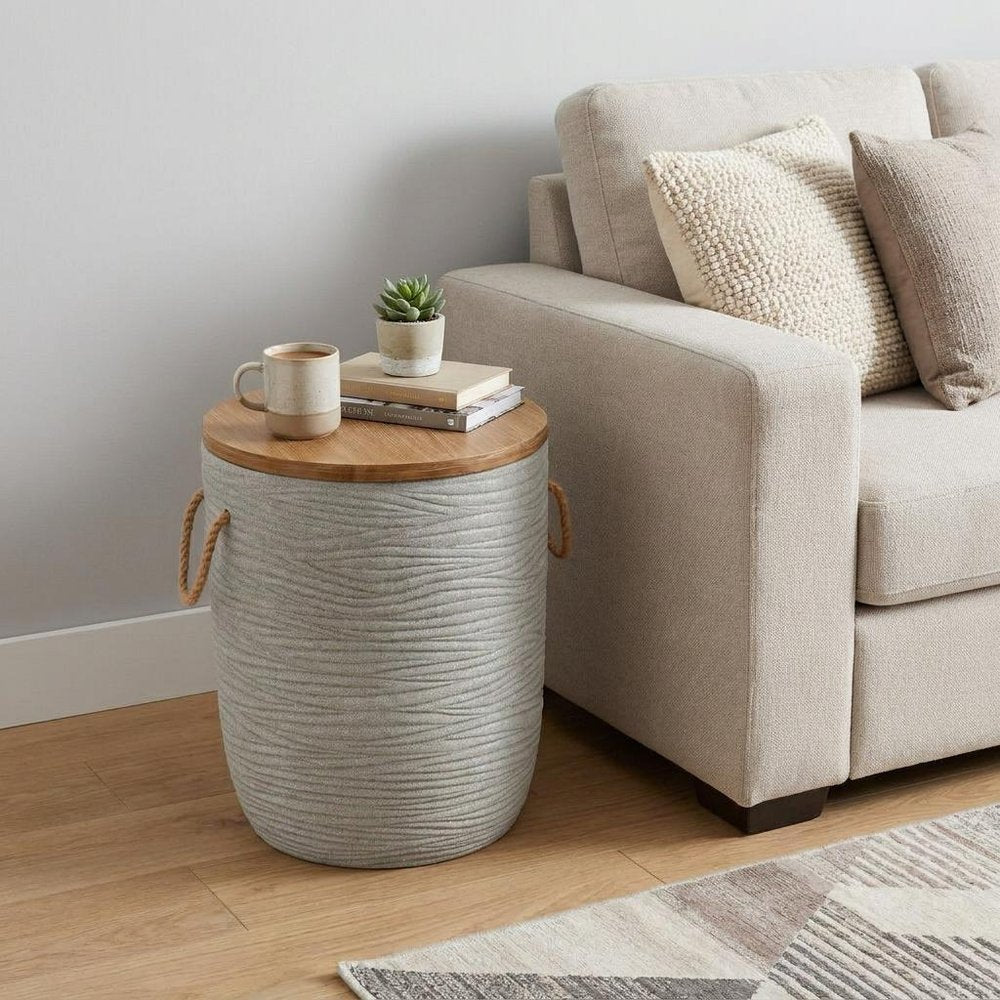 14" Natural and Gray Solid Wood and Faux Concrete Round Outdoor Side Table styled in a furnished interior with an off-white wall on a wood floor.