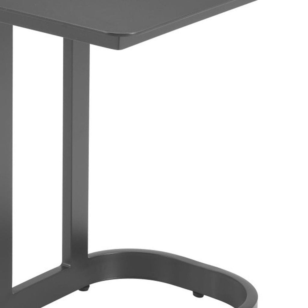 Close-up of a black aluminum outdoor side table with a curved base and a flat top, set against a white background.
