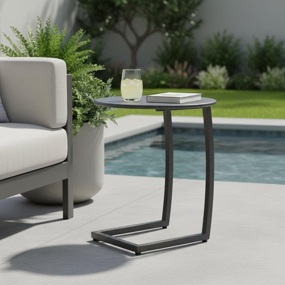 20" Black Aluminum Round Outdoor Side Table shown outdoors on a tiled patio with greenery.