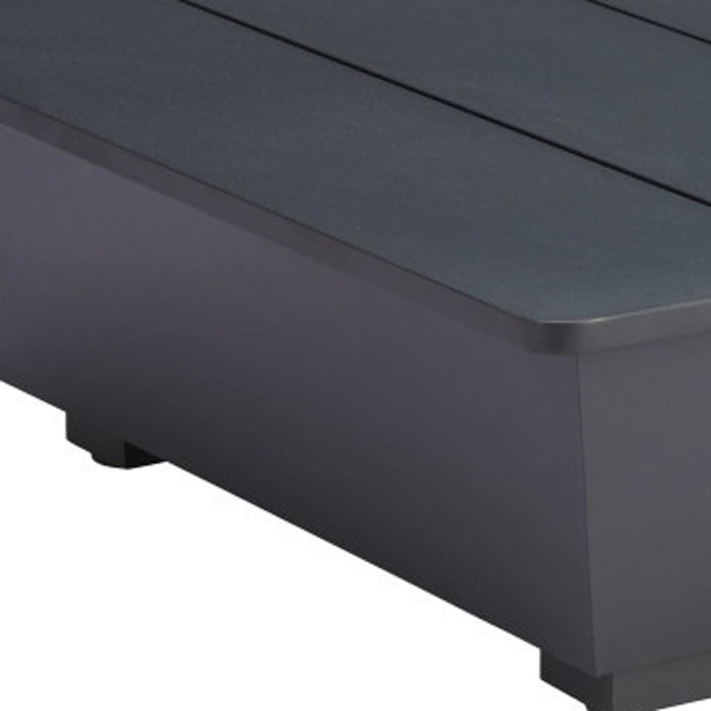 Close-up of a gray aluminum outdoor coffee table with a slatted top and a solid base.