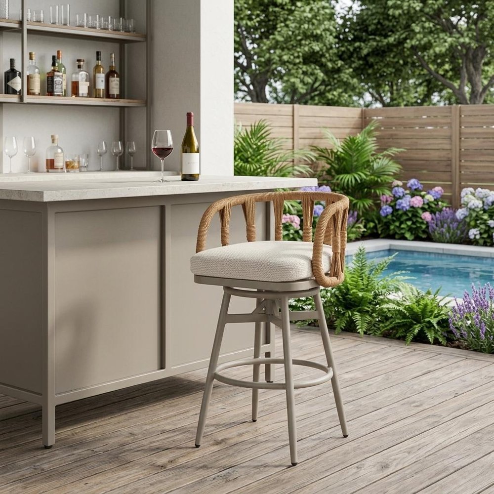 30" Gray Natural and White Aluminum And Faux Rattan Swivel Bar Height Chair shown outdoors on a patio with greenery.