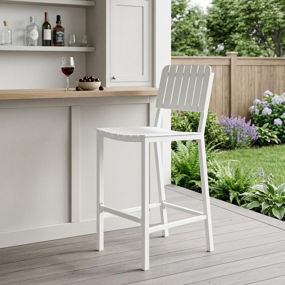 30" White Aluminum Outdoor Bar Height Chair shown outdoors on a tiled patio with greenery.