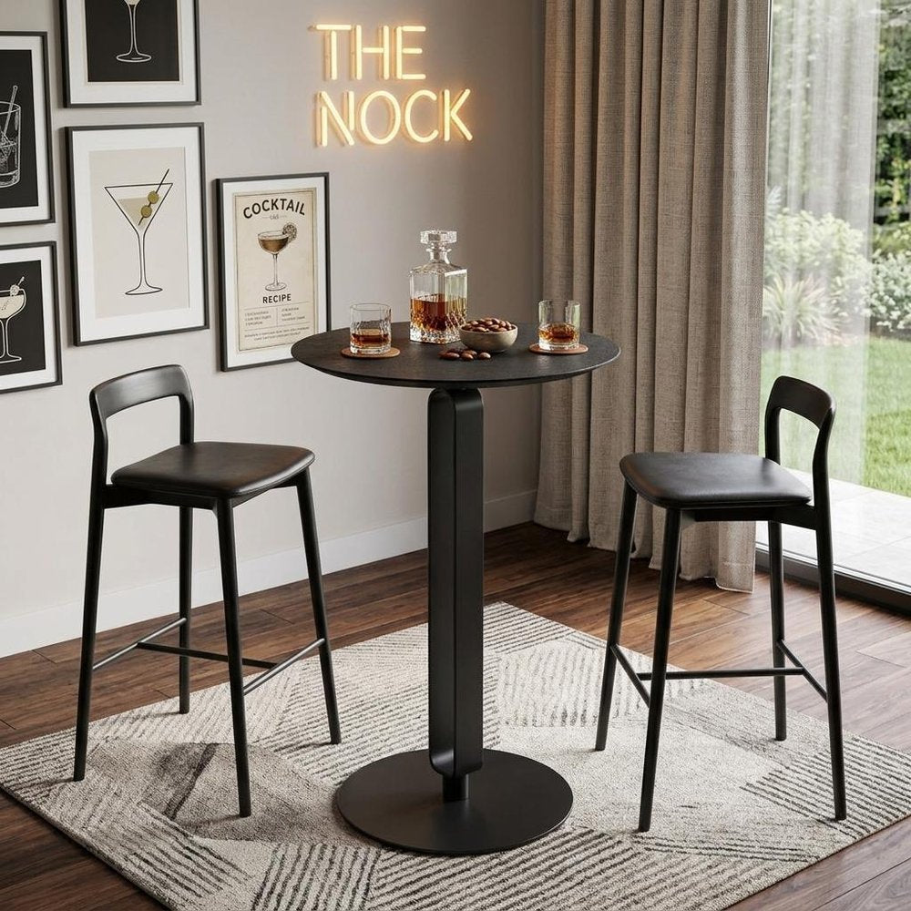 24" Black Wood and Steel Rounded Bar Table styled in a furnished interior with a light gray wall on a wood floor.