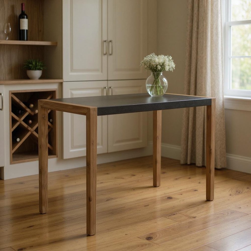 56" Gray And Natural Faux Concrete And Solid Wood Outdoor Bar Table styled in a furnished interior with a dark brown wall on a wood floor in tan wood.