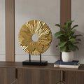 12" Gold Resin Sunflower Hand Painted Tabletop Sculpture styled in a furnished interior with a gray wall on a dark wood floor.