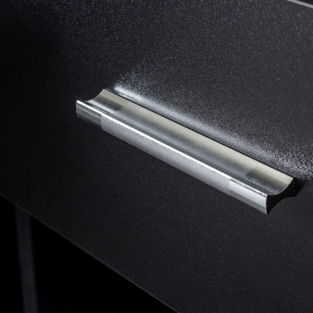 Close-up of a silver metal drawer pull on a textured black surface.