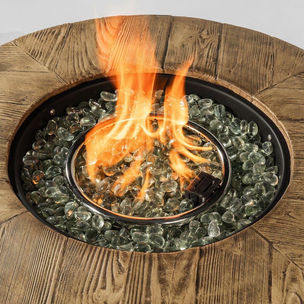 Close-up of a round fire pit with flames, clear glass rocks, and a wood-look finish.