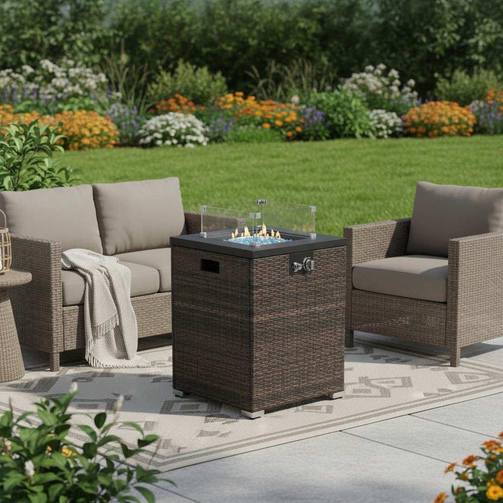 50000 BTU 22" Brown Wicker Propane Rectangular Fire Pit shown outdoors on a tiled patio with greenery.