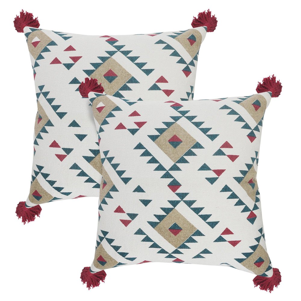 Two white cotton throw pillows with a geometric pattern in teal, tan, and crimson, featuring red tassels on the corners, on a white background.