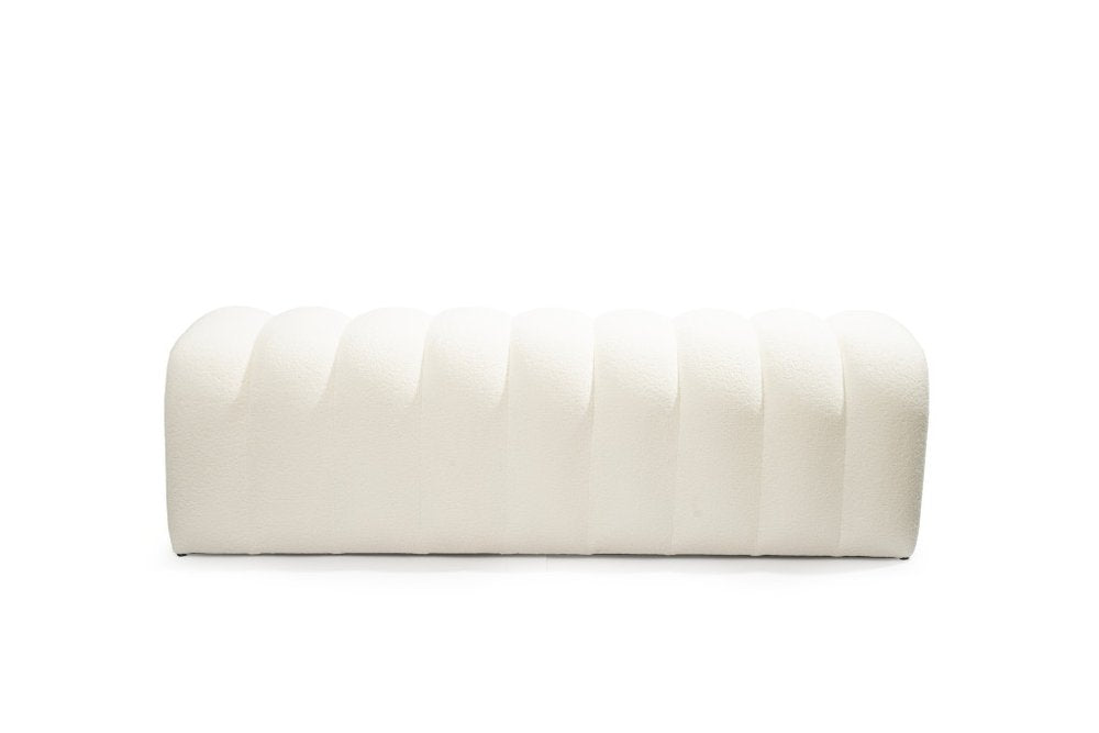 White boucle upholstered bench with vertical tufting on a white background.