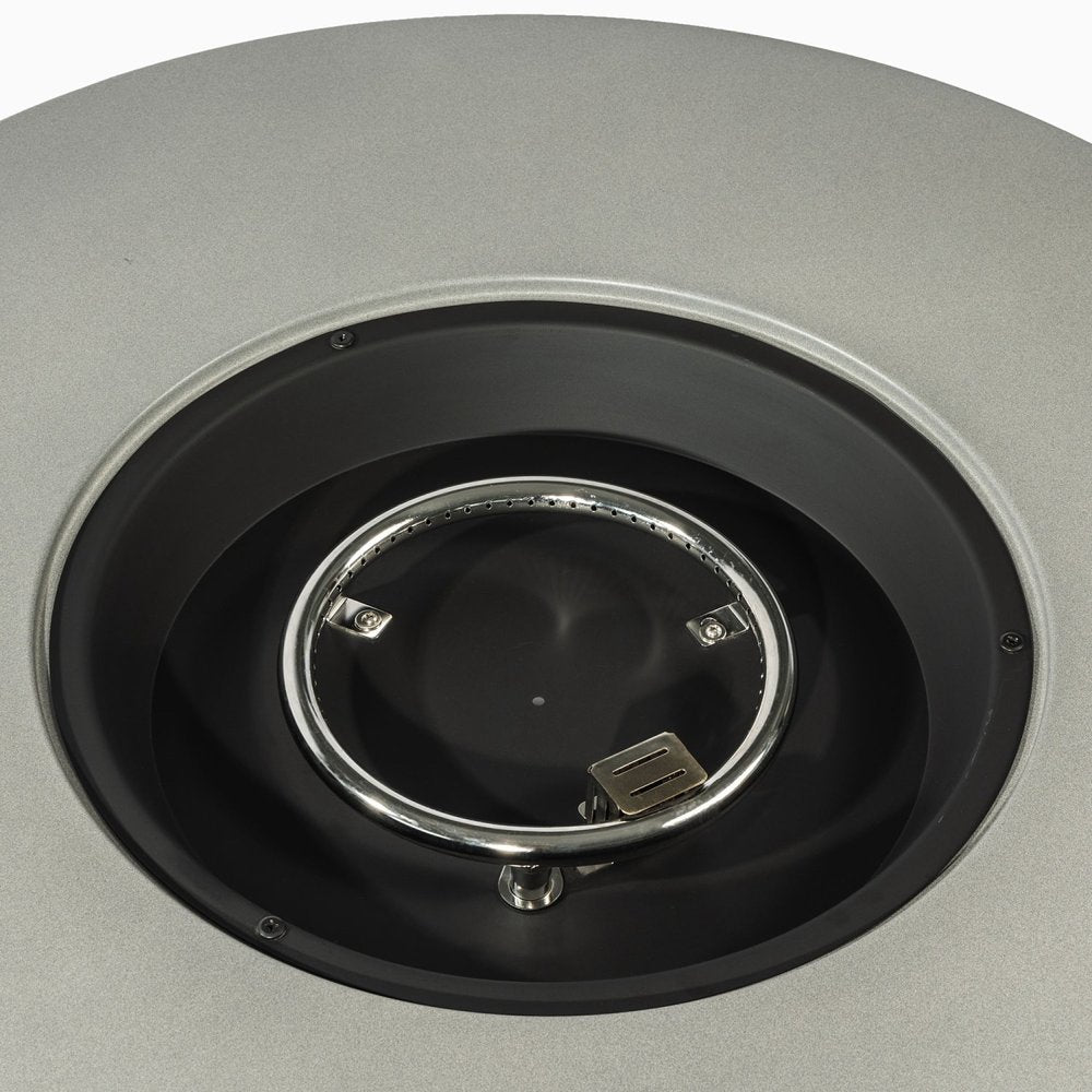 Close-up of a round, gray steel propane fire pit burner ring with visible holes and a metal igniter.