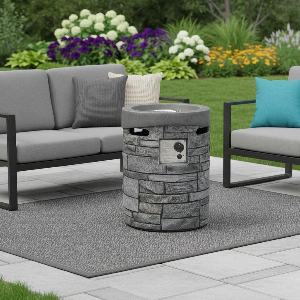 32000 BTU 26" Gray Magnesium Oxide Propane Round Fire Pit With Cover shown outdoors on a patio with greenery.