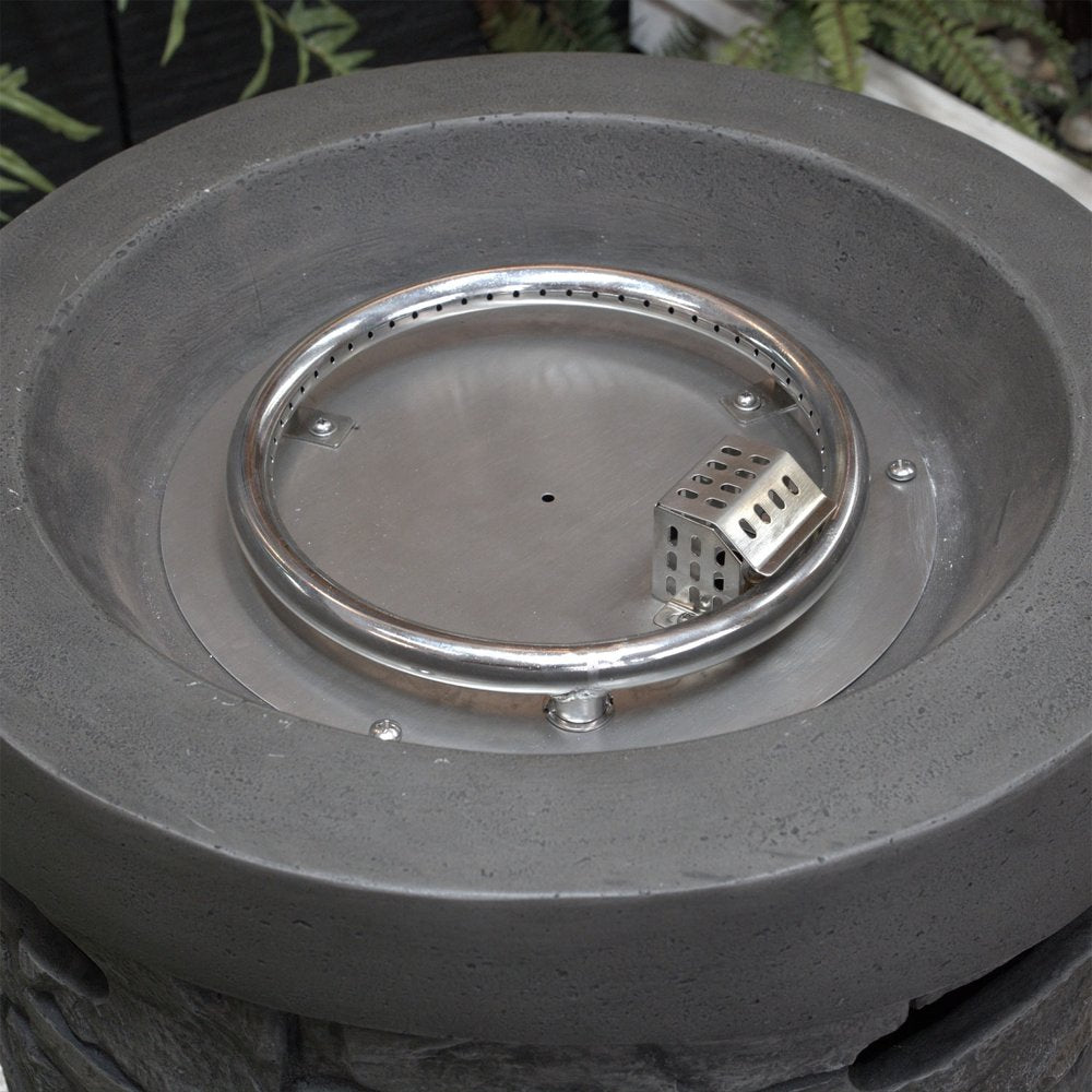 Close-up of a gray magnesium oxide round fire pit with a stainless steel burner ring and igniter.