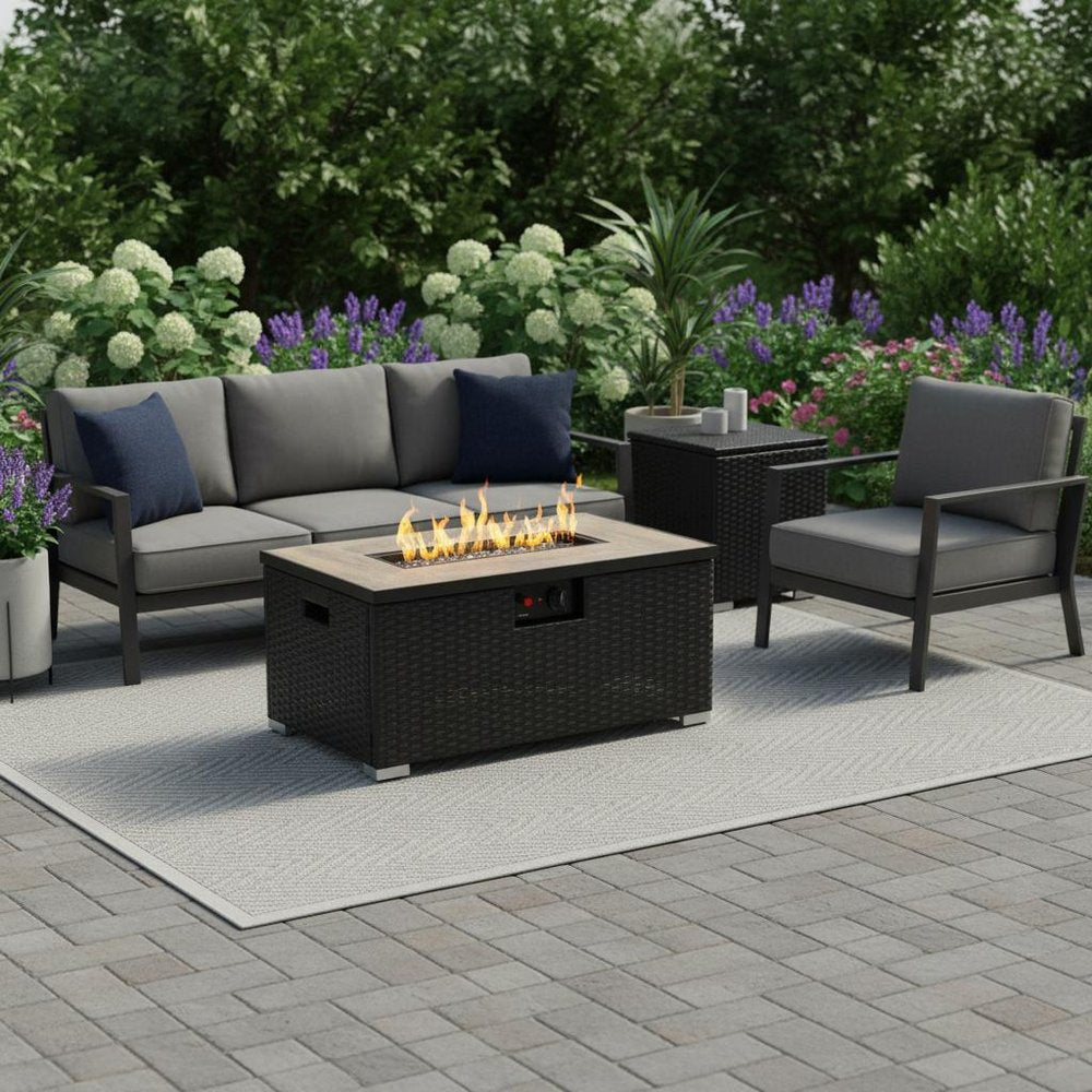 40000 BTU 32" Brown Wicker Propane Rectangular Fire Pit With Cover shown outdoors on a tiled patio with greenery.