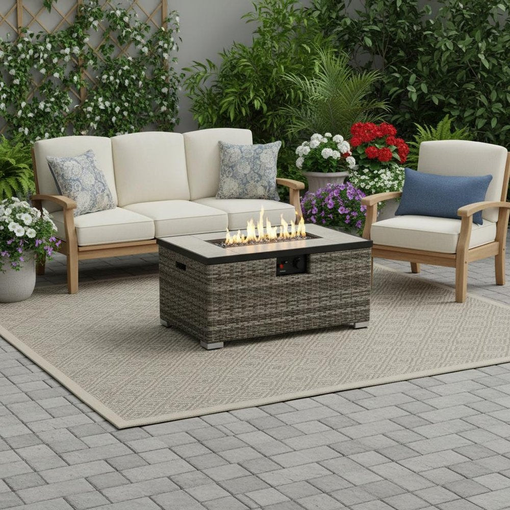 50000 BTU 32" Beige Iron Propane Rectangular Fire Pit With Cover shown outdoors on a tiled patio with greenery.