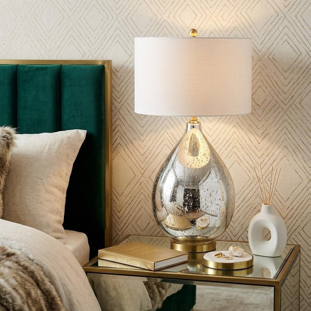 31" Gold Novelty Table Lamp With Globe Shade displayed on a wood tabletop in a furnished interior against a cream wall.