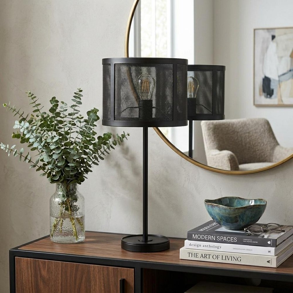 25" Black Table Lamp With Globe Shade displayed on a dark wood tabletop in a furnished interior against a light gray wall.