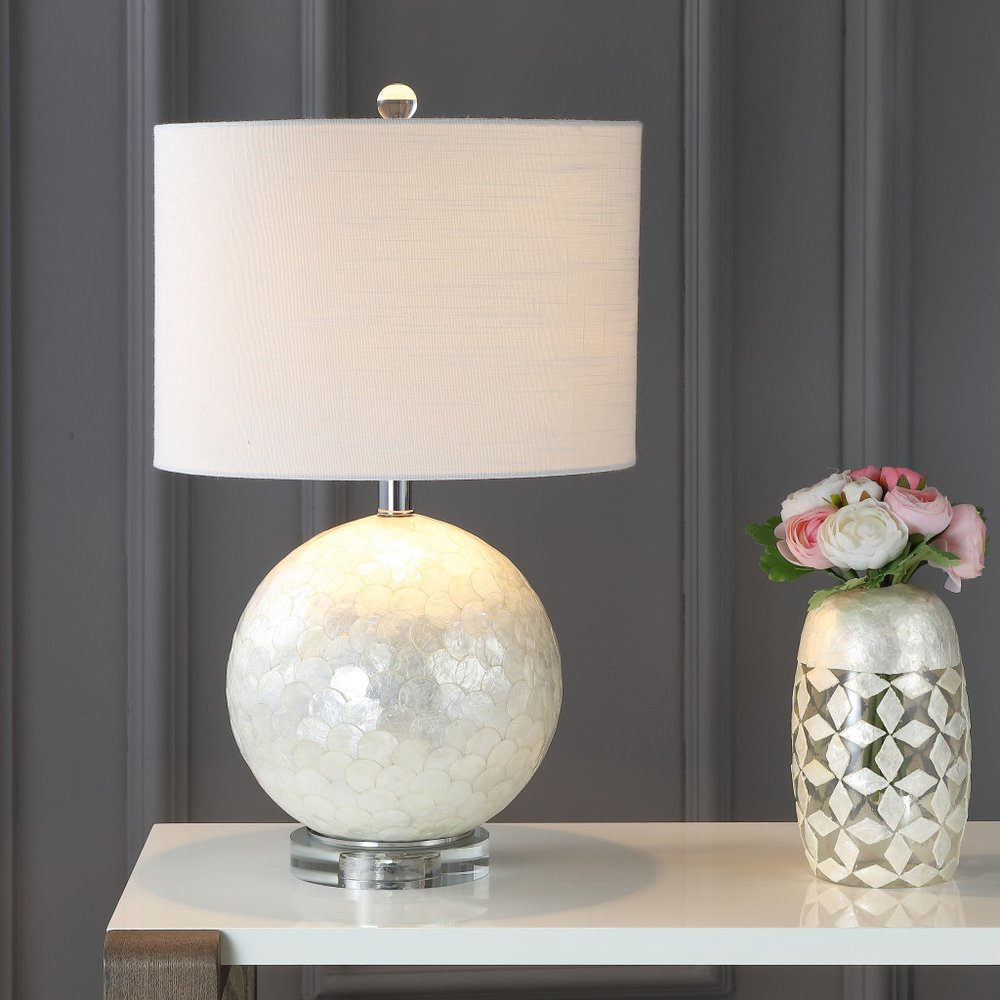 24" Clear Globe Lamp Base With Drum Shade styled in a furnished interior with a dark wall on a charcoal floor.