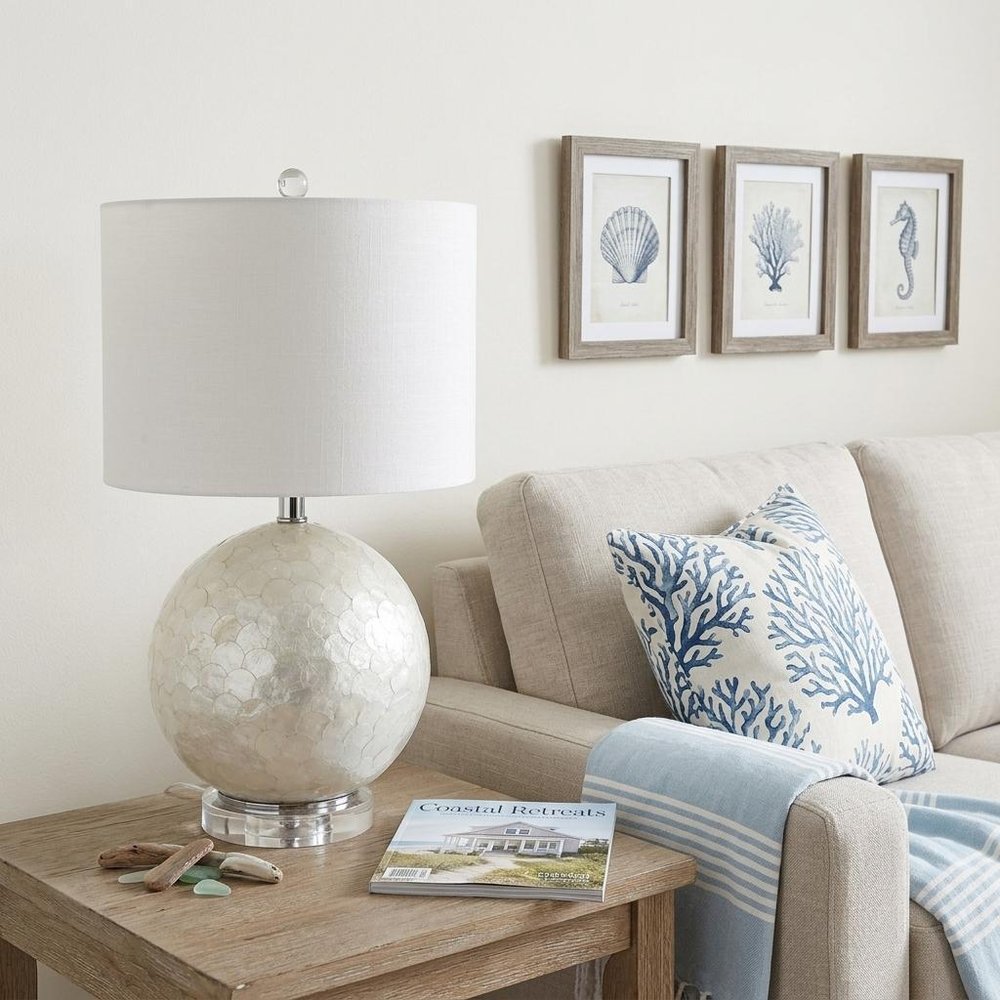 24" Clear Globe Lamp Base With Drum Shade styled in a furnished interior with an off-white wall on a wood floor.