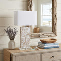 29" Clear Novelty Table Lamp With Shade displayed on a wood tabletop in a furnished interior against an off-white wall.