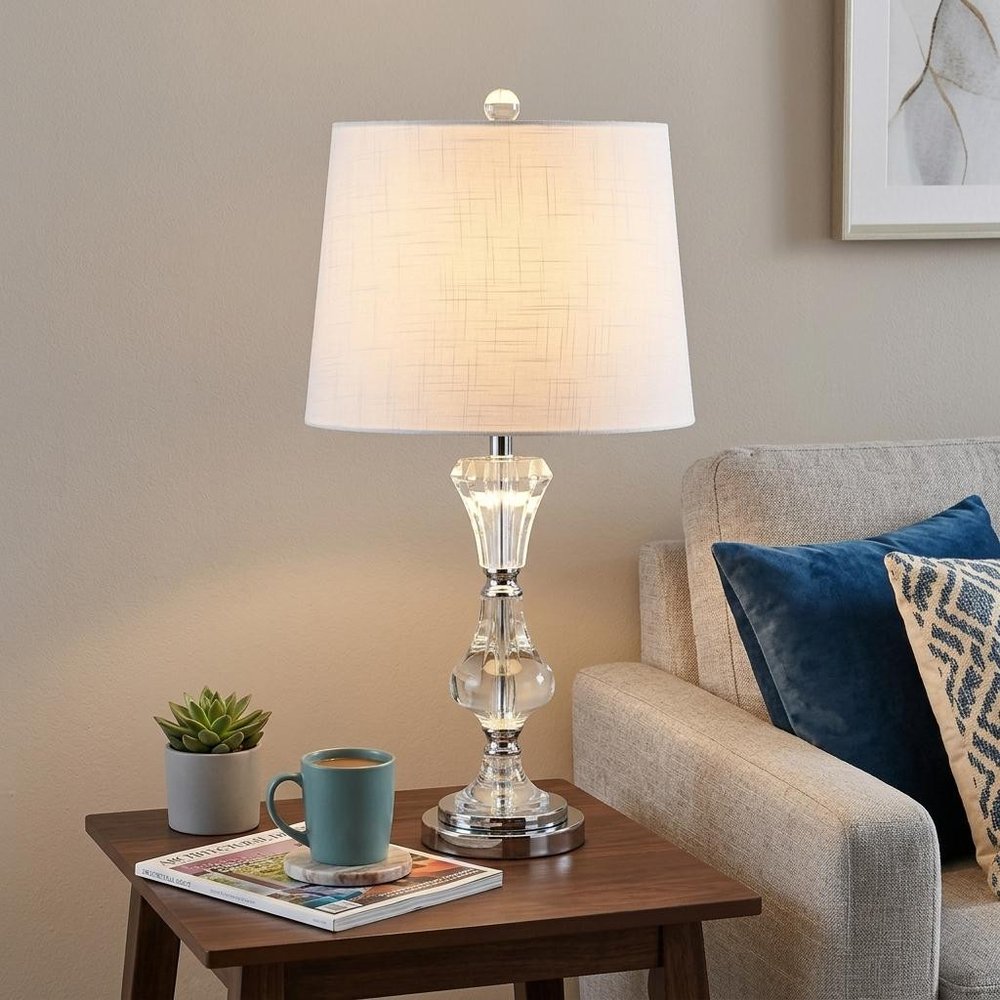 25" Silver Urn Table Lamp With Empire Shade displayed on a dark wood tabletop in a furnished interior against a tan wall.