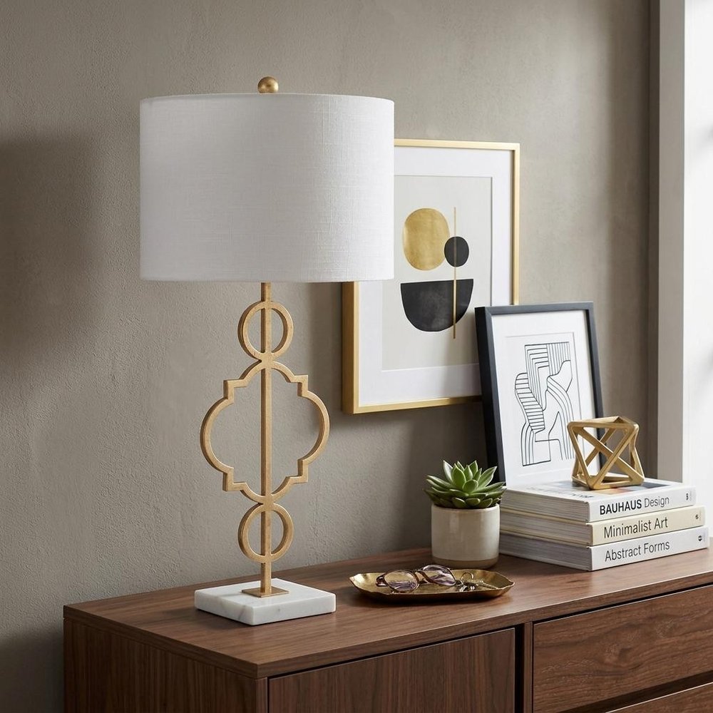 31" White Novelty Table Lamp With Drum Shade displayed on a dark wood tabletop in a furnished interior against a tan wall.
