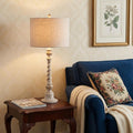 33" White Table Lamp With Drum Shade displayed on a tabletop in a furnished interior against a cream wall.