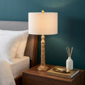 29" Antiqued Gold Table Lamp With Drum Shade shown outdoors on an outdoor setting.