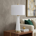29" Gold Novelty Table Lamp With Globe Shade displayed on a dark wood tabletop in a furnished interior against a tan wall.
