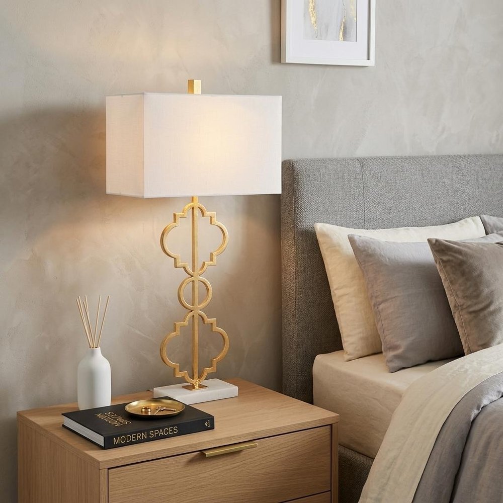 32" White Geometric Table Lamp With Shade displayed on a dark wood tabletop in a furnished interior against a cream wall.